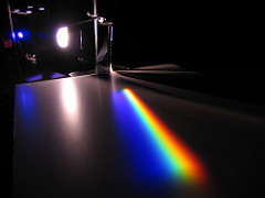 A photo of white light hitting a prism and separating out into colours